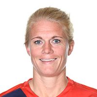 En smilende Solveig Guldbrandsen med kort, blondt hår iført rød sportstrøye med blå aksent, satt mot hvit bakgrunn.