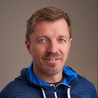 Selvsikker og uformell: Geir Nordseth, en mann med lys skjeggstubber og knallblå øyne, iført en blåmønstret hettegenser, stirrer direkte inn i kameraet med et subtilt smil