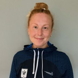 En smilende Malin Andersson med håret bundet, iført en blå sportshettegenser med hvit logo på venstre bryst, og Nike swoosh på siden.